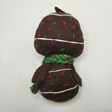 Chocolate Cake back with sprinkles, icing, and a red and green scarf on a white background