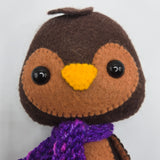 Felt Chocolate Penguin face with purple scarf on a white background