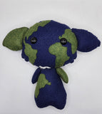 Handmade felt plush inspired by planet Earth, featuring a deep blue body with green continent shapes across the head and body. The soft plush has black button eyes, small arms, and wide ears, creating a cute world-themed character design.
