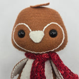 Close-up of a gingerbread penguin face with a red scarf on a white background