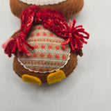 Small plush Gingerbread Penguin body with a red scarf and stomach with red ball patterns and white line patterns on it on a light gray background
