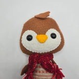 Small Gingerbread Penguin with a white face and a red scarf on a white background