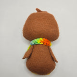 Gingerbread Penguin back with rainbow scarf on a light gray background