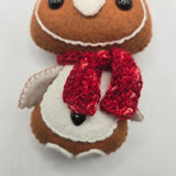 Stuffed gingerbread penguin body with a red scarf on a white background