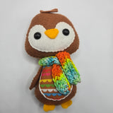 Gingerbread Penguin with a white face and rainbow stomach and scarf on a white background
