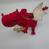 Handmade red felt dragon plush with white wings, small horns, and black button eyes. The soft stuffed dragon stands upright with a curved tail and stitched details.
