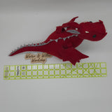 Handmade red felt dragon plush with gray wings, small white horns, and black button eyes. The soft dragon has a stitched gray belly and stands upright with outstretched wings.