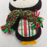 Penguin body with a plaid stomach and red and green scarf on a white background