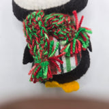 Penguin body with a plaid stomach and red and green scarf on a white background
