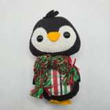 Felt penguin with a plaid stomach and red and green scarf on a white background