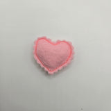 Pink heart-shaped felt ravioli on a gray background