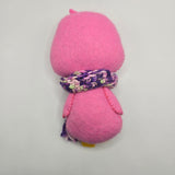 Pink penguin back with multicolored purple scarf on a light gray background