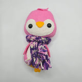 Pink plush penguin with a multicolored purple scarf on a white background