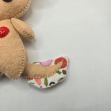 Pizza topping-patterned toy tail on a white background