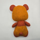 Back of toy bear made of felt on a white background