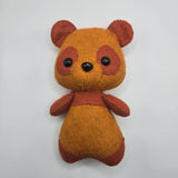 Small brown bear plush toy on a white background