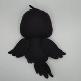 Handmade black raven felt plush with black button eyes, layered felt wings, and a textured beak. The soft stuffed bird features small tail feathers and a tuft of feathers on top of its head, creating a cute raven-inspired plush design.