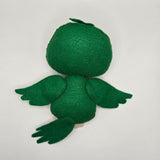 Handmade felt parrot plush inspired by a watermelon, featuring a green head and wings, red cheek accents, and a striped green, white, and red body with black seed details. The plush has a yellow beak, black button eyes, and colorful tail feathers.