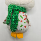 Small plush white penguin with a green scarf on a white background