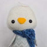 Close-up of a Winter-themed Penguin with a white face and a blue scarf on a white background