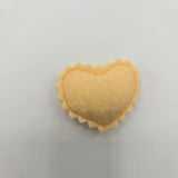 Yellow felt ravioli on a light gray background