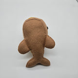 Handmade whale plush designed like a hot dog with mustard topping, soft brown food-themed whale stuffed animal on white background.